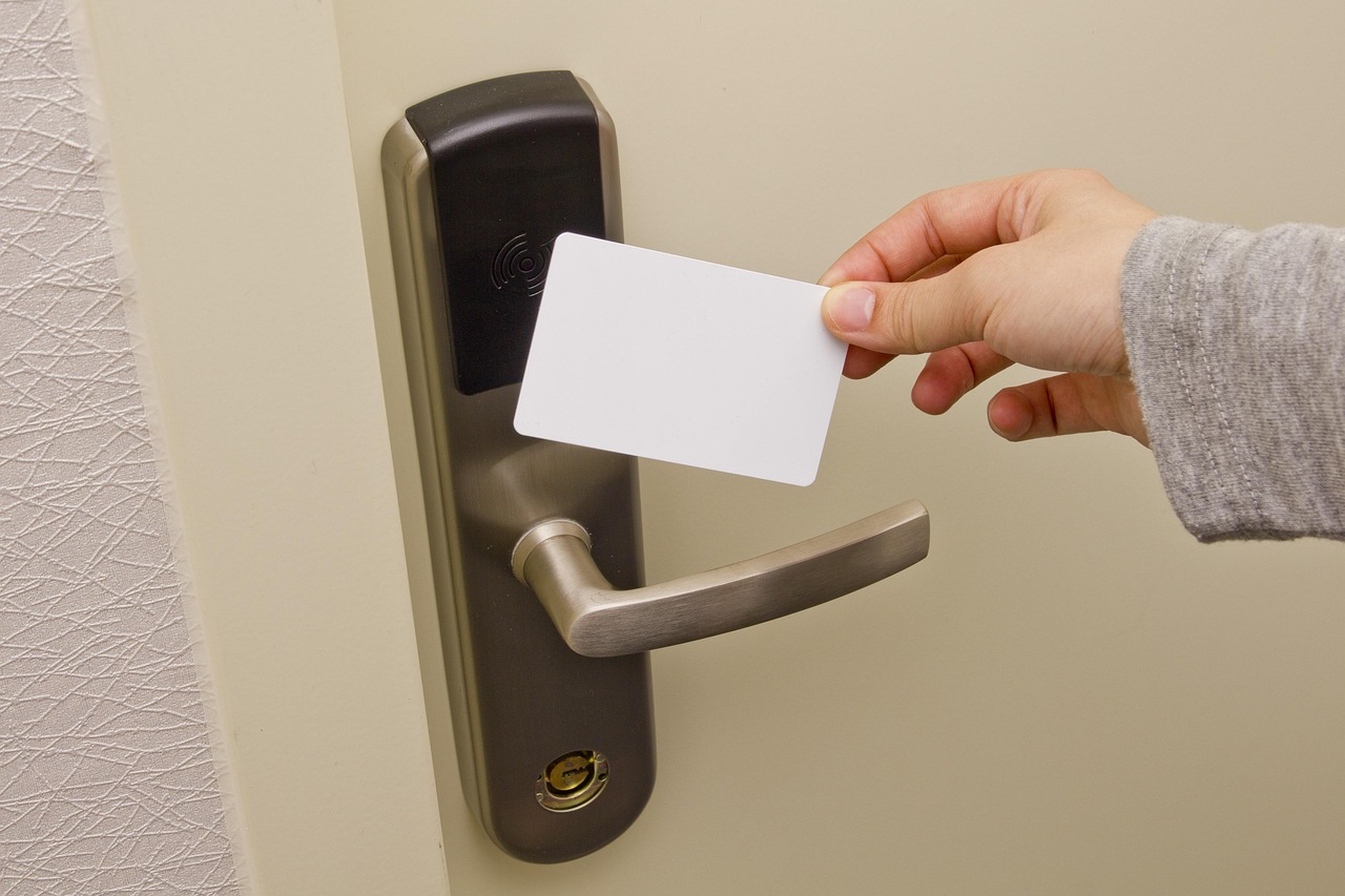 Employee using an HF RFID access card on an office door reader