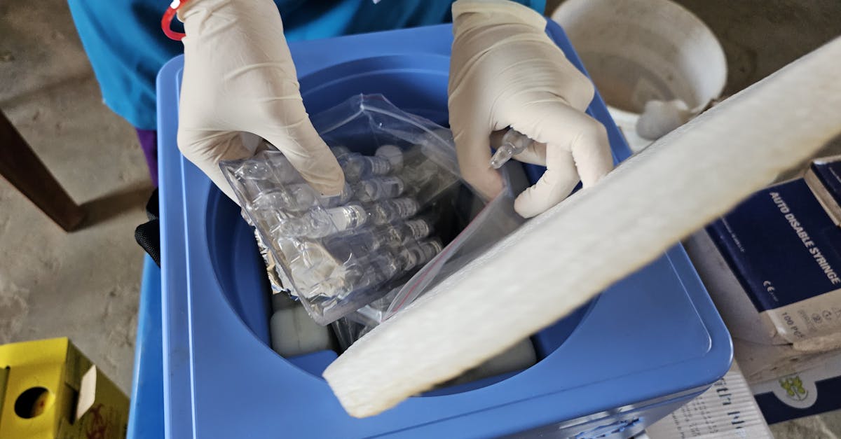 Healthcare worker using gloves handling medical vials in a laboratory setting.