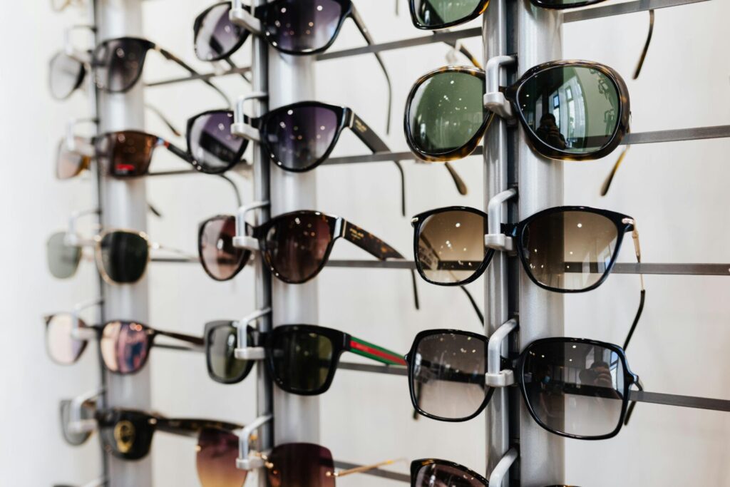 A stylish display of various sunglasses in a modern eyewear store with reflective surfaces.