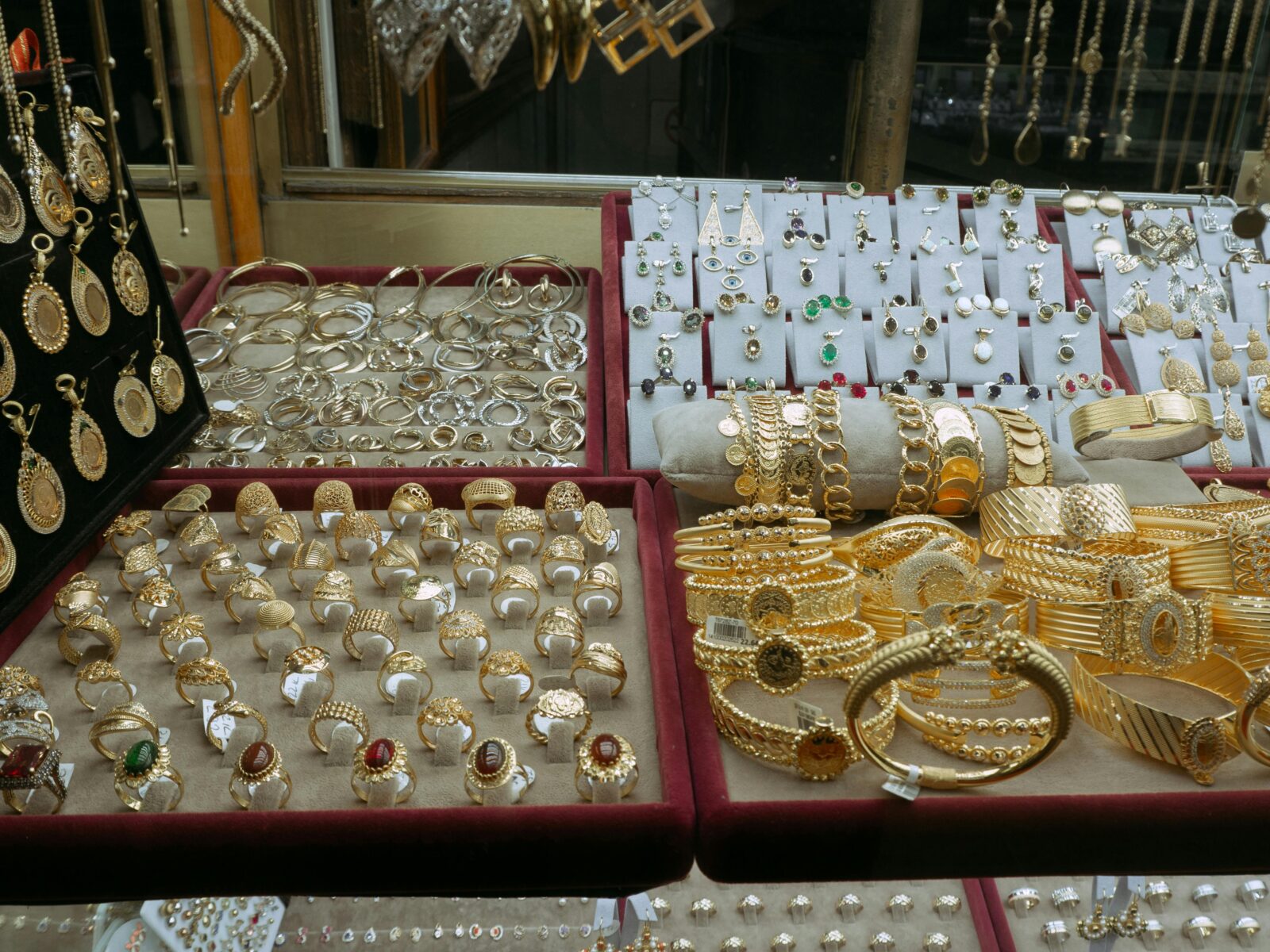 Showcase of elegant gold and silver jewelry in an Istanbul market's display case.